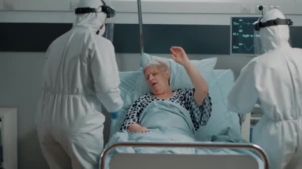 Sjukvårdare i skyddsdräkter hjälper sjuka patienter — Stockvideo