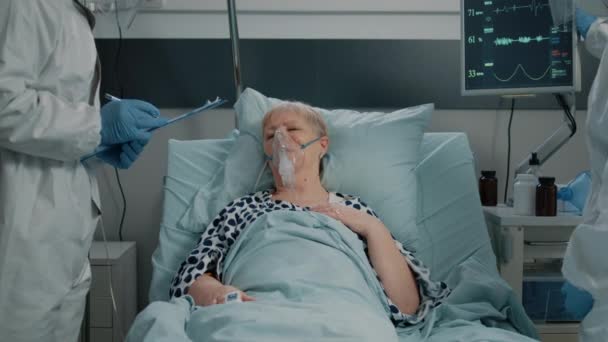 Парамедики консультируют тяжело дышащую женщину с кислородной трубкой — стоковое видео
