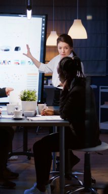 Çok ırklı iş adamları fazla mesai yaparak yönetim stratejisini analiz ediyorlar