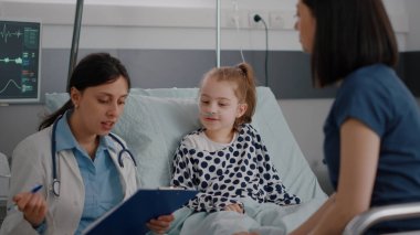 Hastanelik olan küçük hasta kız, ameliyattan sonra yatakta yatıyor.