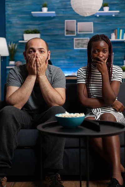 POV di coppia interrazziale essere scioccato guardando film drammatico — Foto Stock