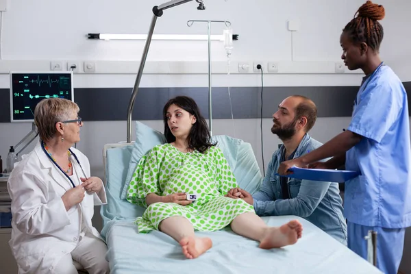 Multietniskt medicinskt team konsult kvinna med graviditet — Stockfoto