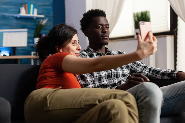 Alegre interracial casal tomando selfies juntos no casa — Fotografia de Stock