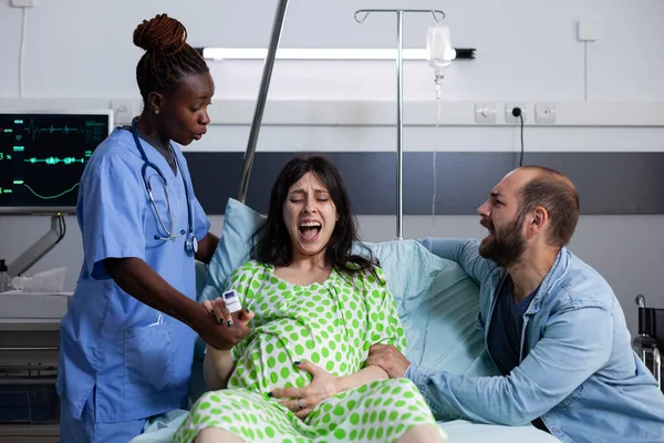 Mladá žena při porodu křičí z kontrakcí — Stock fotografie