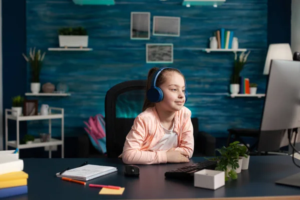 Маленька дитина в навушниках має онлайн-урок математики на комп'ютері — стокове фото