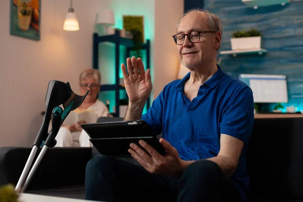 Anziani che salutano al tablet con videoconferenza — Foto Stock