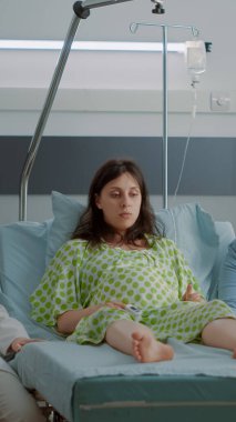 Çok ırklı doktor ve hemşire hamile bir kadınla konuşuyor.