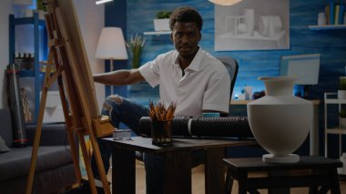 Beyaz tuval üzerine vazo tasarımı çizen Afrikalı bir Amerikalı.