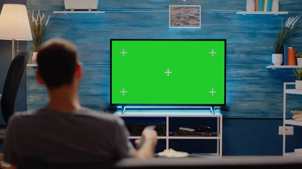 Человек с телевизором на зеленом фоне — стоковое фото