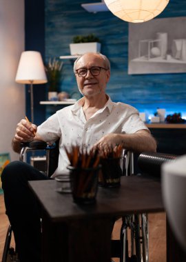 Sanat stüdyosunda sanatsal hobisi olan engelli bir adamın portresi.