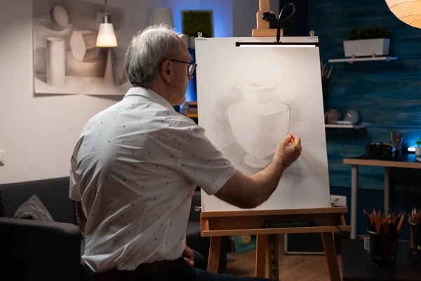 Artista idoso trabalhando no desenho do vaso com lápis sobre tela — Fotografia de Stock