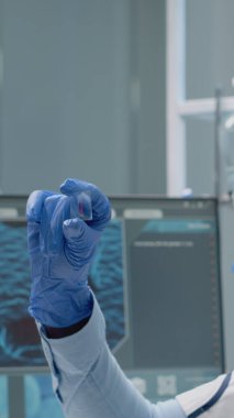 Kimya uzmanı camdaki kan örneğini analiz ediyor.