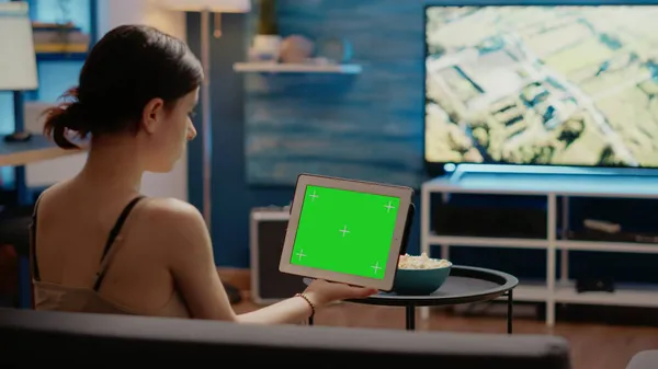 Mladý člověk se dívá na tablet s horizontální zelenou obrazovkou — Stock fotografie