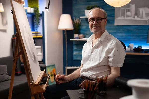 Portrait d'un ancien artiste caucasien assis dans un atelier d'art — Photo