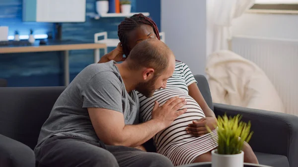 Casal inter-racial esperando criança na sala de estar — Fotografia de Stock