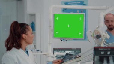 Yeşil ekranlı monitöre bakan dişçiyi kapat