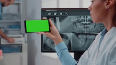 Dişçiye git ve yeşil ekranlı akıllı telefonu analiz et.