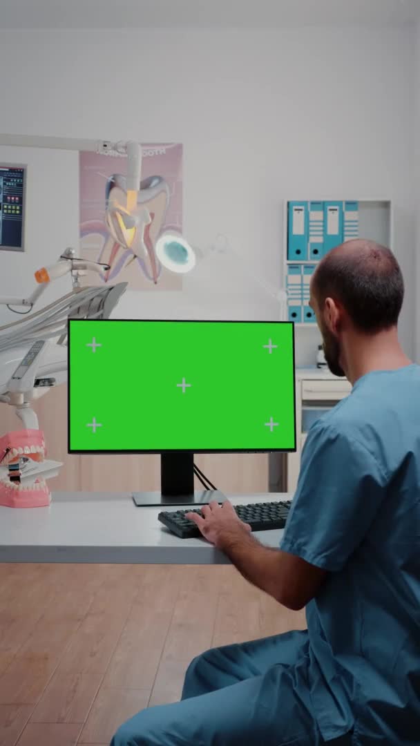 Verticale video: Assistent met horizontaal groen scherm op de computer — Stockvideo