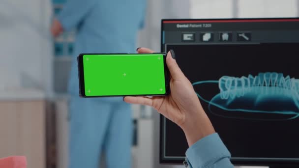 Gros plan de l'orthodontiste tenant l'écran vert horizontal — Video