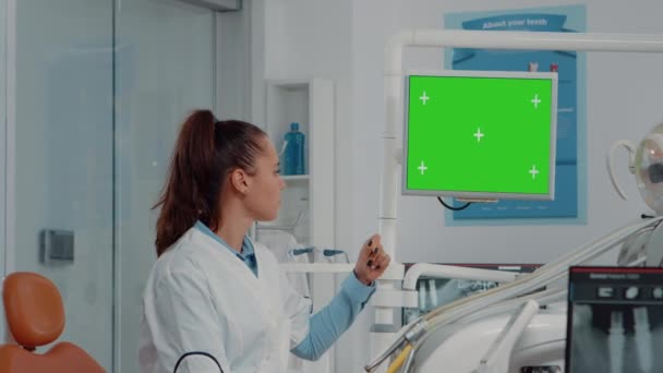 Dentysta analizuje poziomy zielony ekran na monitorze — Wideo stockowe