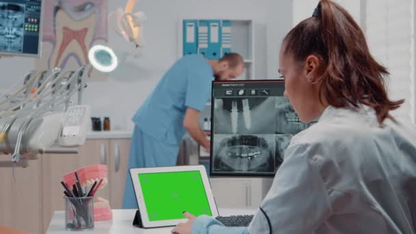 Orthodontist met horizontaal groen scherm op tablet — Stockvideo