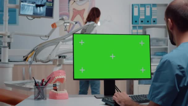 男护士看着显示器上的水平绿色屏幕 — 图库视频影像
