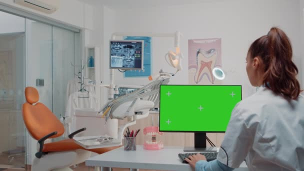 Frau arbeitet als Zahnärztin mit grünem Bildschirm am Bildschirm — Stockvideo