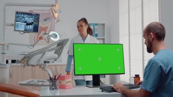 Βοηθός που χρησιμοποιεί οριζόντια πράσινη οθόνη στον υπολογιστή — Αρχείο Βίντεο