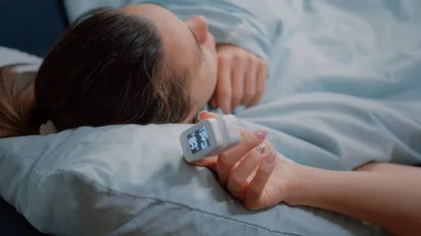 Oximéter közelítése egy beteg nő kezén, aki beteg. — Stock Fotó