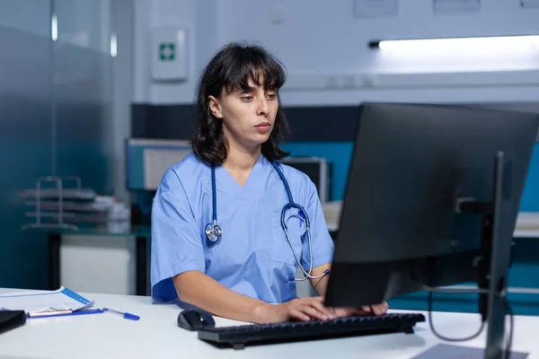 Arzthelferin mit Tastatur und Computer im Büro — Stockfoto