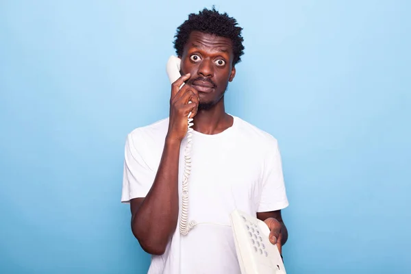 Hombre contestando el teléfono sonando mientras posaba en el estudio — Foto de Stock