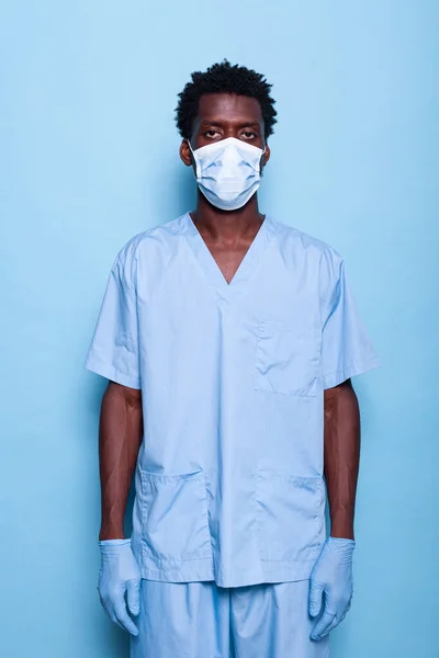 Homem enfermeira de pé no estúdio sobre fundo azul — Fotografia de Stock