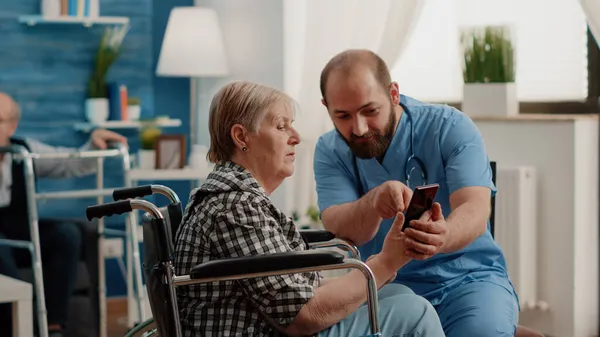 男子护士教残疾退休妇女使用智能手机 — 图库照片