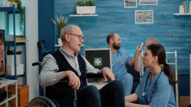 Engelli bir adamı hastalıkla ilgili rahatlatan kadın hemşire.