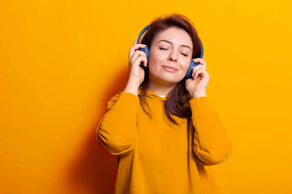 Relaxado mulher caucasiana gostando de música em fones de ouvido — Fotografia de Stock