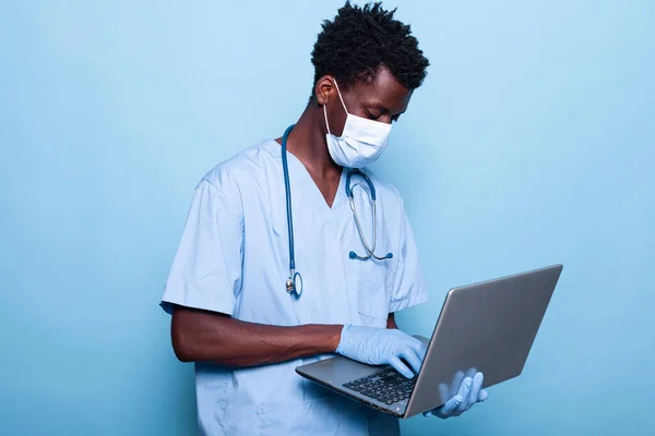 African american nurse with uniform holding laptop — Stock Photo, Image