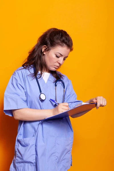 Жінка медсестра з формами написання на кишені паперу — стокове фото