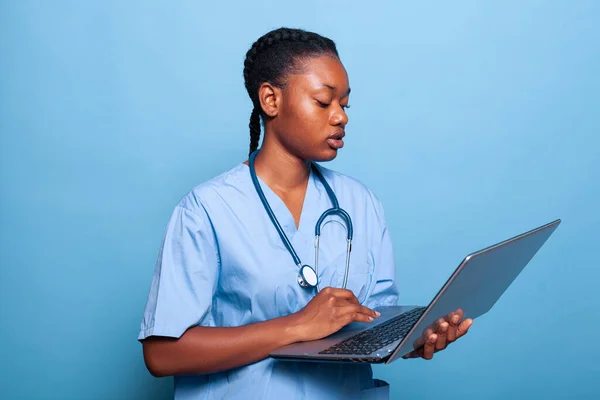 Assistente especialista afro-americano segurando laptop computador digitando experiência doença — Fotografia de Stock