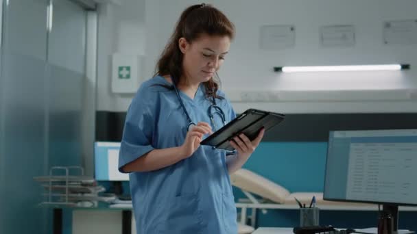 Mulher trabalhando como enfermeira e segurando tablet digital — Vídeo de Stock