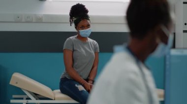 Yüz maskeli genç hasta tıbbi teşhisi bekliyor.