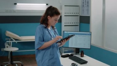 Bilgi için tablet ekranına bakan tıbbi asistan