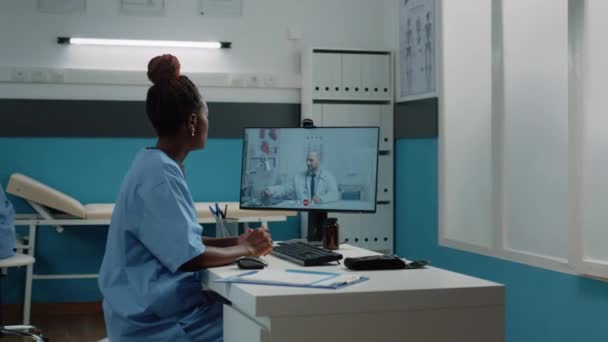 Assistente médico usando comunicação de videochamada para telessaúde — Vídeo de Stock