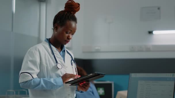 Медик смотрит на экран планшета для системы здравоохранения — стоковое видео