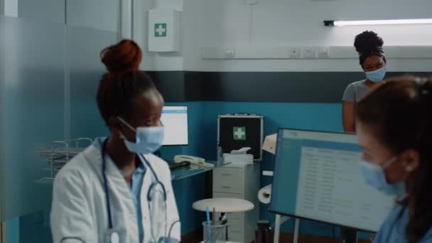 Afrikai amerikai beteg az ágyban nézi a változatos orvosi csapat — Stock videók
