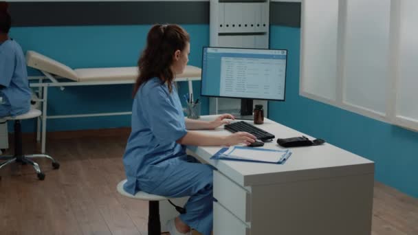 Mujer que trabaja como enfermera con ordenador y documentos — Vídeos de Stock