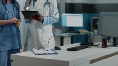 Tabletteki teşhisi analiz eden bir grup doktor ve hemşire.