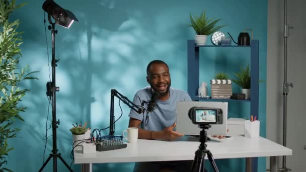 Sosyal medya etkileyicisi podcast için kamerada dizüstü bilgisayarı gözden geçiriyor — Stok video