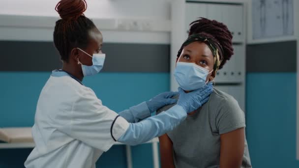 Médico afroamericano haciendo examen en paciente joven — Vídeos de Stock