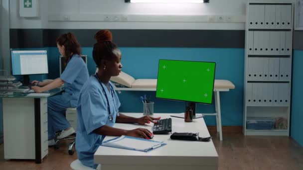 Asystent medyczny korzystający z komputera z poziomym zielonym ekranem — Wideo stockowe