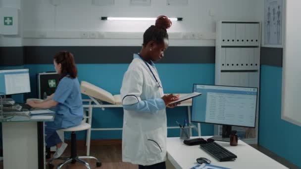 Kobieta pracująca jako lekarz i trzymająca tabletkę cyfrową — Wideo stockowe